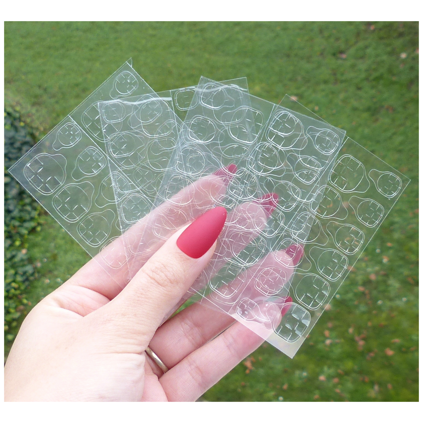 Plaque de 96 adhésifs double face pour faux ongles, posée à plat sur fond neutre