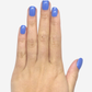 Main portant faux ongles courts bleu clair brillants visibles sur poing fermé