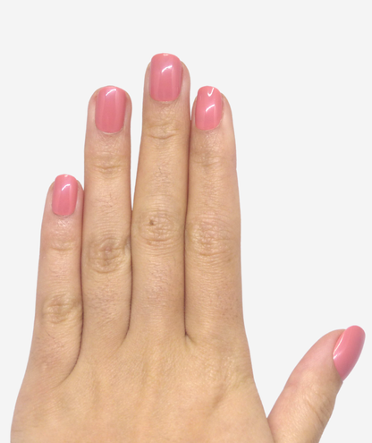 Main avec des faux ongles rose arrondi court