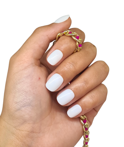Main fermée avec faux ongles blancs brillants, forme arrondie courte, 5 ongles visibles