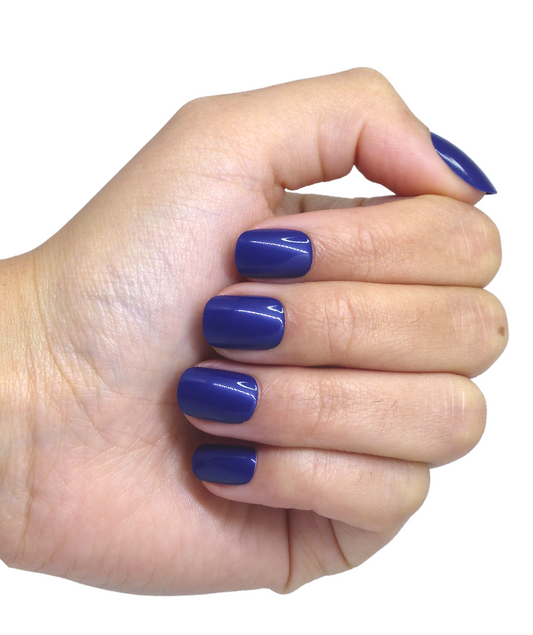 Main avec faux ongles courts bleus electrique brillants, main fermée visible