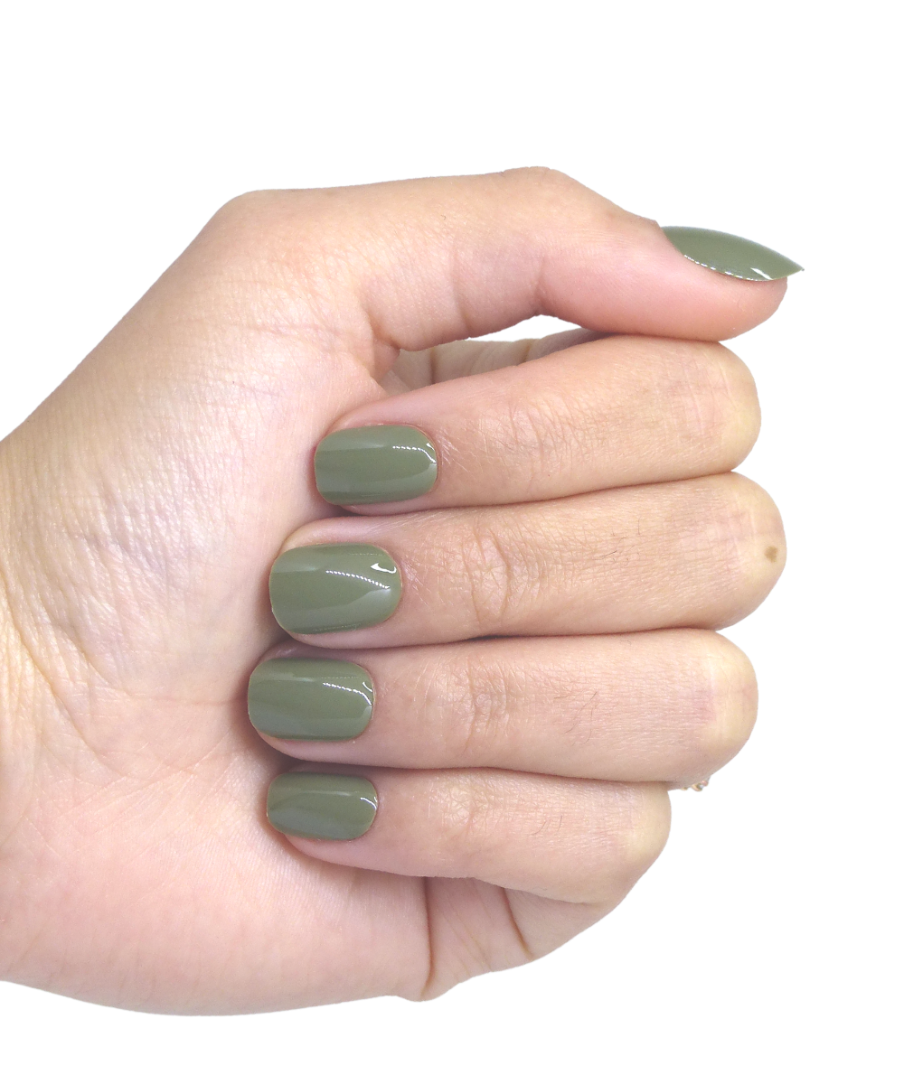 Main portant faux ongles courts vert kaki brillants, 5 doigts visibles